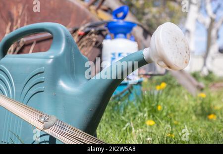 Blue plastic pot for watering in the garden. Can water. Watering can for flowers on the street, in the garden or garden on a warm summer sunny day. Stock Photo