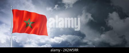 Moroccan flag on a cloudy sky Stock Photo