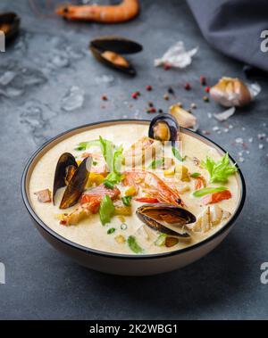 New England clam chowder, occasionally referred to as Boston or Boston-style Clam Chowder. Creamy soup with shrimp, corn, bacon and mussels Stock Photo