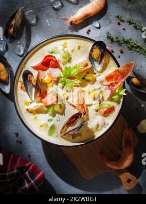 New England clam chowder, occasionally referred to as Boston or Boston-style Clam Chowder. Creamy soup with shrimp, corn, bacon and mussels Stock Photo