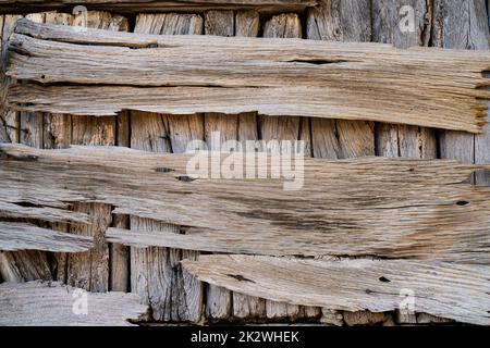 front view closeup of rustic weathered brown barn wood background with knots and nail holes damaged by weather and insects Stock Photo