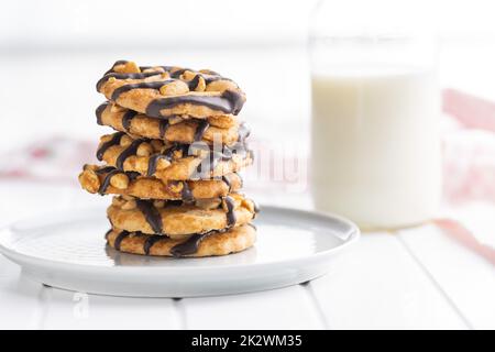 Chip cookies with peanuts and chocolate strips on white table. Stock Photo