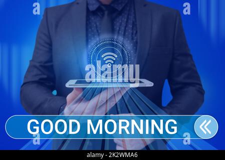 Writing displaying text Good Morning. Conceptual photo A conventional expression at meeting or parting in the morning Man holding Screen Of Mobile Phone Showing The Futuristic Technology. Stock Photo