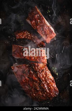 Delicious barbecued ribs seasoned with a spicy basting sauce and served on iron pan. Stock Photo