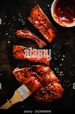 Delicious barbecued ribs seasoned with a spicy basting sauce and served on iron pan. Stock Photo