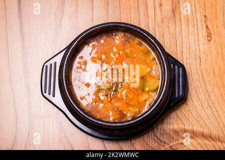 Korean traditional Kimchi Jjigae soup in bowl in the restaurant Stock Photo