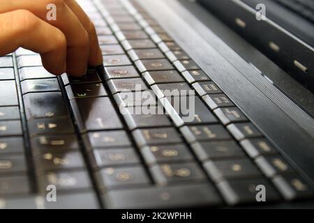 Finger of a female hand press a key on the keyboard of the laptop. Payment Security Concept Stock Photo