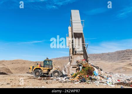 A semitrailer trailer is in a landfill tipper waiting to be dumped out ...