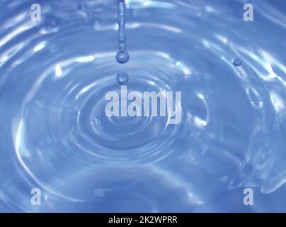Water drop falling into water making a perfect droplet splash Stock Photo