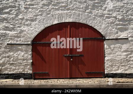 The arching wooden doors secured by locks on an old medieval castle in Kinsale, Ireland Stock Photo