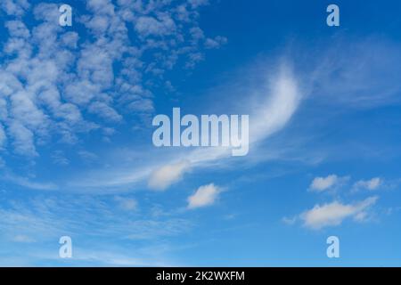 Beautiful blue summer sky and white cirrocumulus clouds background. Cloudscape background. Blue sky and fluffy white clouds on a sunny day. Nice weather in summer. Beauty in nature. Summer sunny sky. Stock Photo