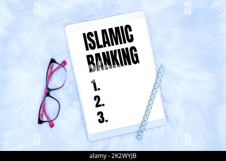 Text sign showing Islamic Banking. Business showcase Banking system based on the principles of Islamic law Office Supplies Over Desk With Keyboard And Glasses And Coffee Cup For Working Stock Photo
