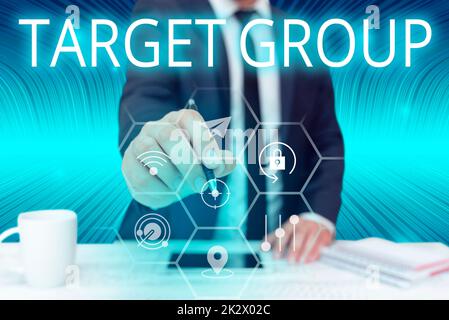 Hand writing sign Target Group. Business overview Particular showing that an advertisement intended to reach to Businessman in suit holding pen symbolizing successful teamwork. Stock Photo