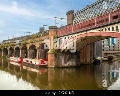 Moored barges on the Bridgewater canal, alongside the Castlefield viaduct. Manchester. UK Stock Photo