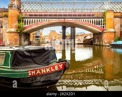 narrowboat moored on the Bridgewater Canal with Victorian railway bridge and Castlefield viaduct in the distance. Castlefield. Manchester. UK Stock Photo