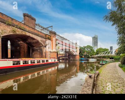 Moored barges alongside the Bridgewater viaduct with Beetham Tower in the distance. Castlefield. Manchester. UK Stock Photo