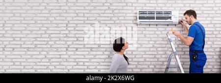 Technician Repairing Air Conditioner With Digital Multimeter Stock Photo