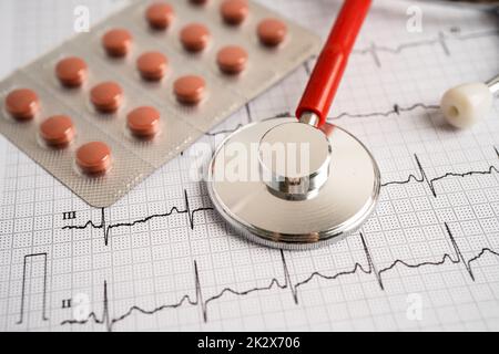Stethoscope on electrocardiogram with capsule pill, heart wave, heart attack, cardiogram report. Stock Photo