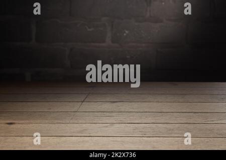 Wooden table against brick wall with shade Stock Photo