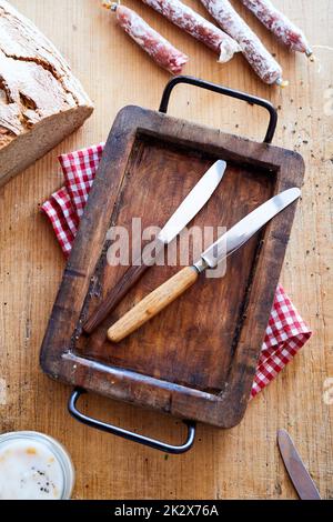 Table knives on wooden tray Stock Photo