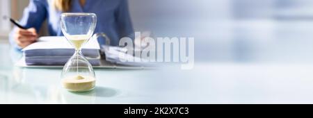 Close-up Of A Hourglass On Desk Stock Photo