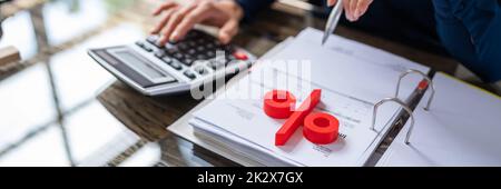 Businessperson's Hand Calculating Bill With Calculator Stock Photo