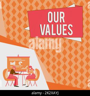 Text sign showing Our Values. Business concept list of morals companies or individuals commit to do them Colleagues Sitting On Desk With Laptop Papers Showing Graphs Conversation Stock Photo