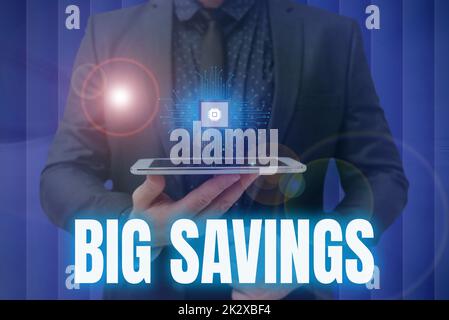 Conceptual caption Big Savings. Concept meaning income not spent or deferred consumption putting money aside Man holding Screen Of Mobile Phone Showing The Futuristic Technology. Stock Photo