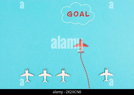 Red airplane is flying to his goal, leadership, courage and winner concept, standing out from the crowd, positive mindset for success in business Stock Photo