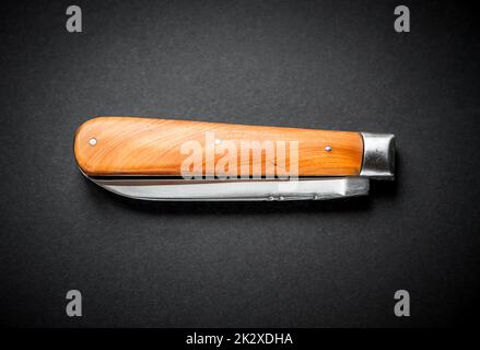 Traditional wooden pocket knife on black background Stock Photo