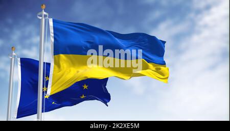 the national flag of Ukraine waving with blurred european union flag on a clear day Stock Photo