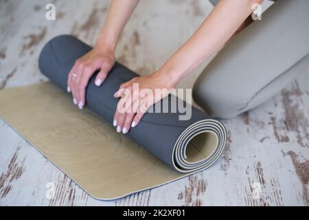 Close-up of a woman's hands preparing a mat for yoga or meditation. Stock Photo