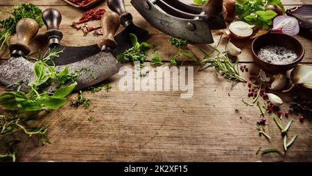 Greens with old fashioned knives on table Stock Photo