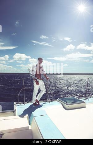 Young man sailing his boat on the open ocean Stock Photo
