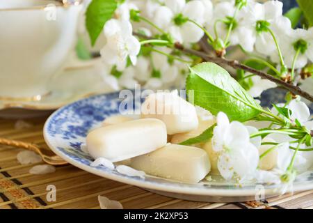 Set of white chocolate candies, tenderness of morning coffee, with white cherry flowers Stock Photo