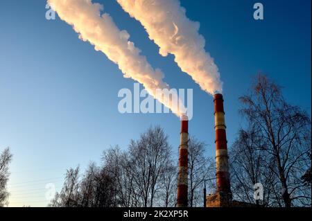 white smoke is coming out of the pipes in the blue sky Stock Photo