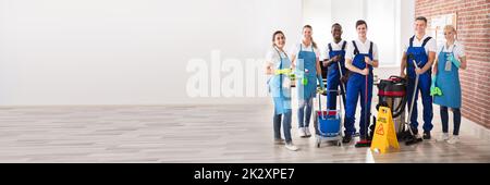 Portrait Of Happy Diverse Janitors In The Office With Cleaning Equipment Stock Photo