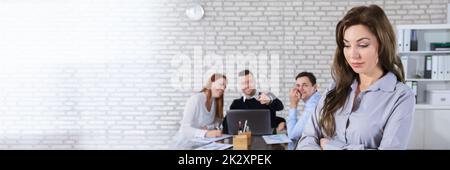 Colleagues Laughing To Her Coworker In Office Stock Photo