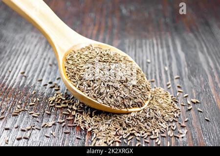 Cumin seeds in spoon on wooden table Stock Photo