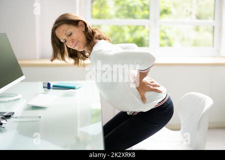 Woman On Sofa Suffering From Backache Stock Photo