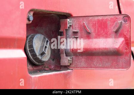 The car's open fuel tank cap was opened to pour gasoline or diesel fuel into the tank at a gas station. The concept of rising fuel prices and transport industry. Stock Photo