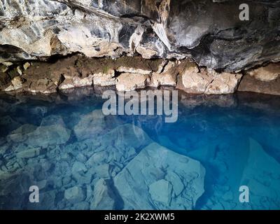 View into Grjotagja lava cave with crystal clear blue water. Stock Photo