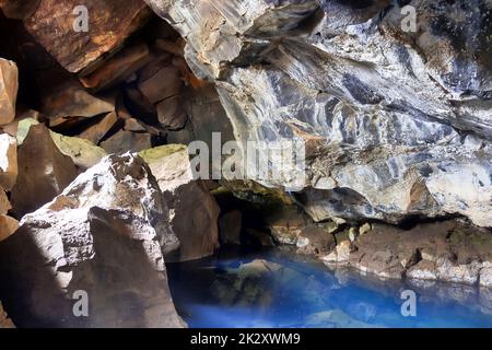 View into Grjotagja lava cave with crystal clear blue water. Stock Photo