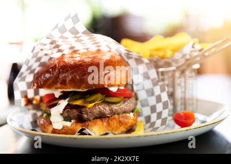 Hamburger in a takeaway container on the wooden background. Food delivery and fast food concept Stock Photo