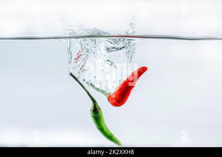 Red chilli, water splashes, solated on a white background Stock Photo