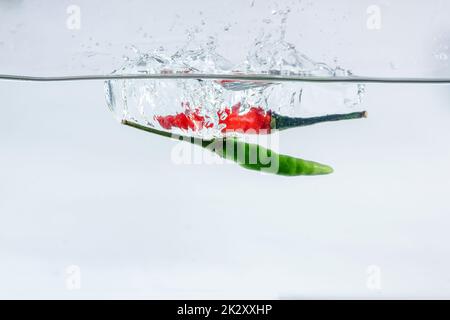 Red chilli, water splashes, solated on a white background Stock Photo