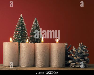 Four Advent candles burning on a red background Stock Photo