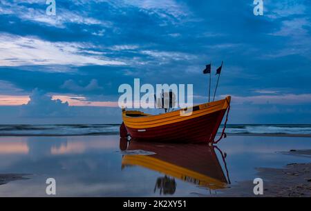 Sunset over Baltic Sea with empty fishing boat - Debki, Pomerania, Poland Stock Photo