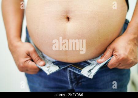 Asian woman show fat belly big size overweight and obesity at office. Stock Photo