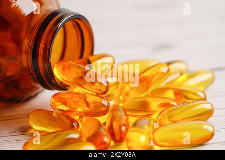 Fish oil or Cod liver oil gel in capsules with omega 3 vitamins, supplementary healthy food . Stock Photo